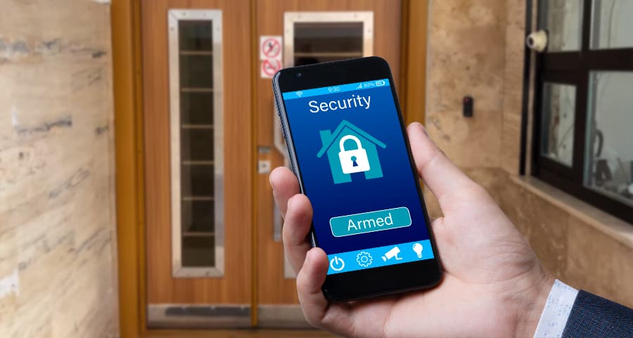 Person using mobile device to arm a security system